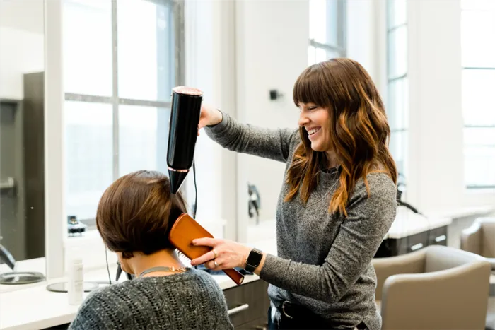 Девушке с тонкими волосами делают одну из процедур для волос в салоне