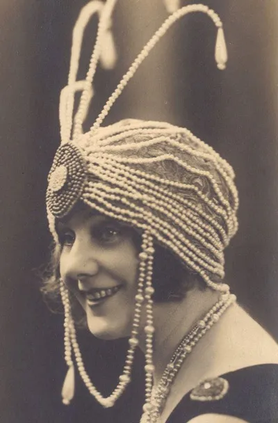 Девушка в шляпке украшенной бусами в стиле Гетсби