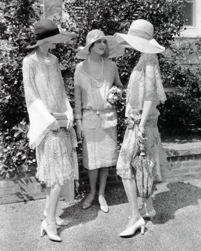 Три девушки одетые в стиле Гетсби, в платьях с заниженной талией и шляпах с широкими полями