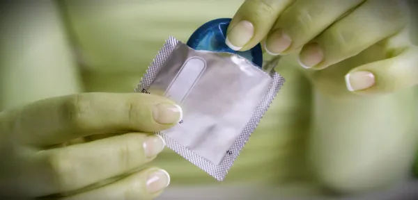 презерватив в женских руках