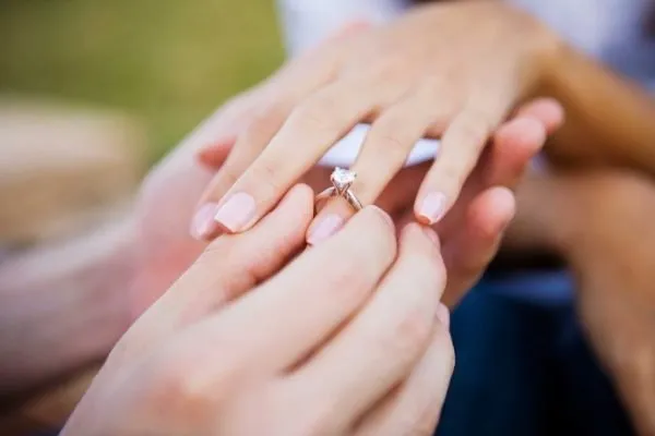 Мужчина надевает кольцо на безымянный палец женщине