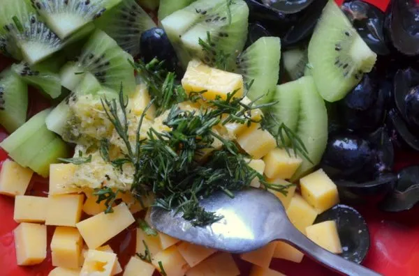 Подготовленные ингредиенты для фруктового салата с сыром и металлическая ложка