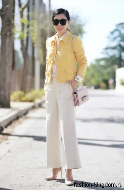 Прямые классические брюки белого цвета, расширенного кроя гармонируют с коротким желтым жакетом.