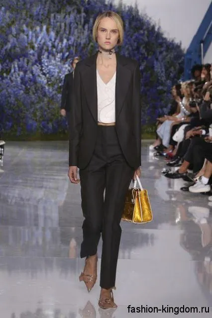 Черные классические брюки прямого кроя в сочетании с черным пиджаком и бежевыми туфлями на каблуке от Dior.