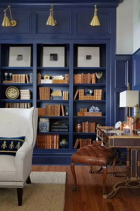 Благородный синий в интерьер библиотеки дополнен мебелью из натуральной кожи и дерева