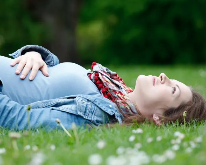 Беременная лежит на траве