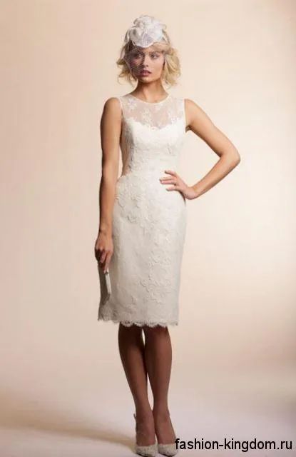 Свадебное платье-футляр белого цвета, с гипюровыми вставками, без рукавов, длиной до колен в сочетании с белыми туфлями на каблуке.