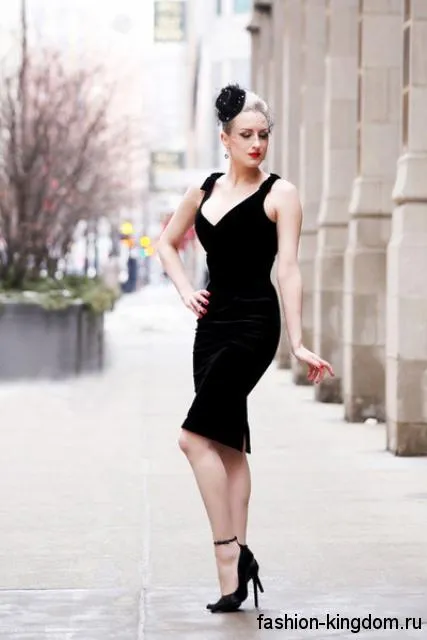 Черное платье-футляр приталенного кроя, длиной до колен, без рукавов сочетается с туфлями черного цвета на каблуке.