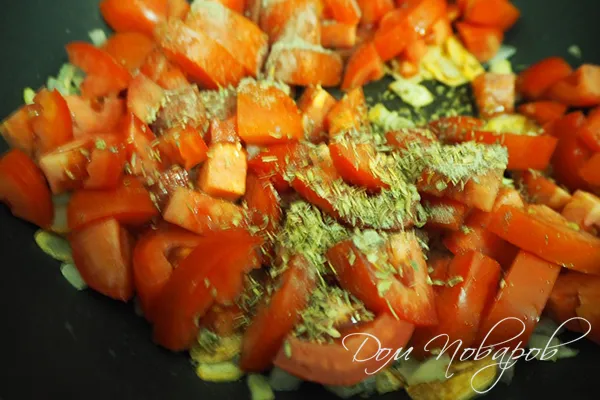 Добавление специй к томатам на сковороде